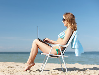 Image showing girl looking at tablet pc on the beach