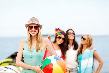 Image showing girl with ball and friends on the beach