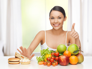 Image showing woman with fruits rejecting junk food