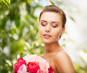 Image showing woman wearing earrings and holding flowers