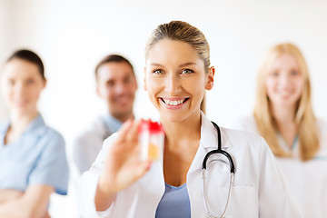 Image showing female doctor with jar of capsules