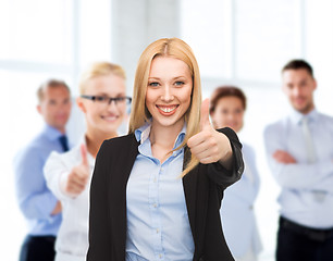 Image showing businesswoman showing thumbs up in office