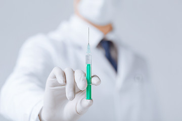 Image showing male doctor holding syringe with injection