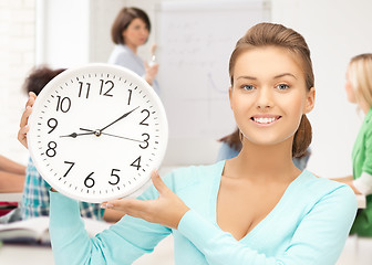 Image showing attractive student pointing at clock