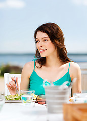 Image showing girl eating in cafe on the beach