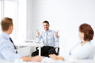 Image showing businessman showing thumbs up in office