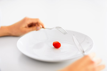 Image showing woman with plate and one tomato