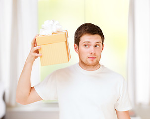 Image showing man in white t-shirt with gift box