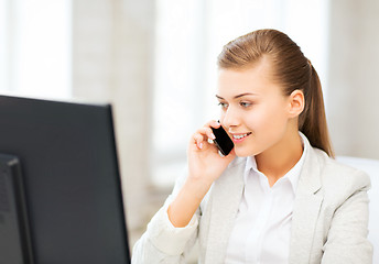 Image showing businesswoman with smartphone in office