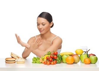 Image showing woman with fruits rejecting hamburger