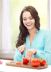 Image showing woman in the kitchen cutting tomatoes