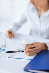 Image showing woman with coffee filling in blank paper