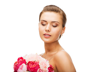 Image showing woman wearing earrings and holding flowers