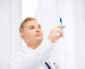 Image showing male doctor holding syringe with injection