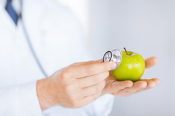 Image showing male doctor with green apple and stethoscope