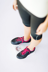 Image showing woman legs standing on scales