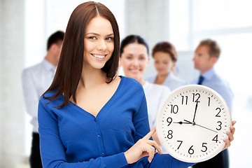 Image showing businesswoman pointing at alarm clock