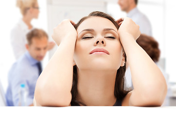 Image showing stressed businesswoman in office