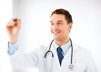 Image showing young doctor working with something imaginary