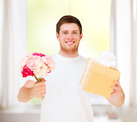 Image showing man holding bouquet of flowers and gift box