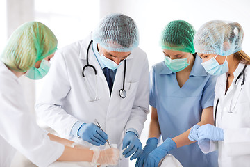 Image showing young group of doctors doing operation