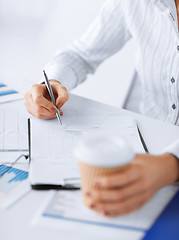 Image showing woman filling in blank paper and drinking coffee