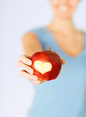 Image showing woman hand holding red apple with heart shape