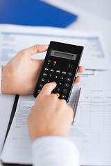 Image showing woman hand with calculator and papers