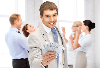 Image showing happy businessman with cash money in office