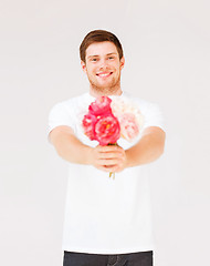 Image showing young man holding bouquet of flowers