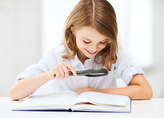 Image showing girl reading book with magnifier at school