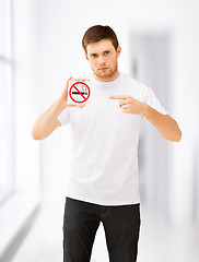 Image showing young man pointing at no smoking sign