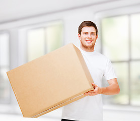 Image showing smiling man carrying carton box