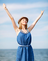 Image showing girl with hands up on the beach