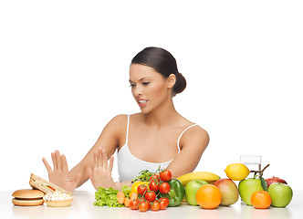 Image showing woman with fruits rejecting hamburger