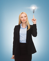 Image showing woman pointing at light bulb