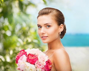 Image showing woman wearing earrings and holding flowers