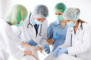 Image showing young group of doctors doing operation