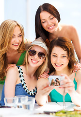 Image showing girls taking photo in cafe on the beach