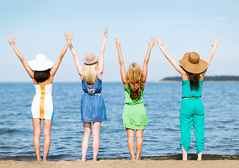 Image showing girls looking at the sea with hands up