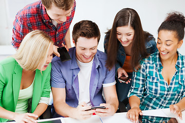 Image showing students looking into smartphone at school