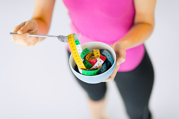 Image showing woman hands holding bowl with measuring tape