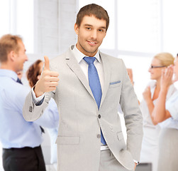 Image showing businessman showing thumbs up in office