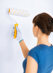 Image showing woman with roller and paint colouring the wall