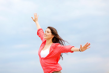 Image showing girl with hands up on the beach