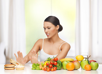 Image showing woman with fruits rejecting junk food