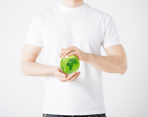 Image showing man hands holding green sphere globe