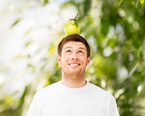 Image showing man with green apple on his head