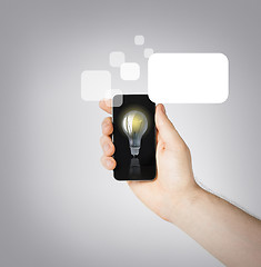 Image showing man hand holding smartphone with light bulb