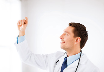 Image showing young doctor holding something imaginary